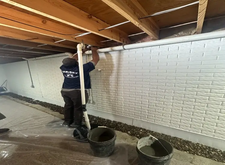 Professionals are prepping a basement for waterproofing in Monessen, PA